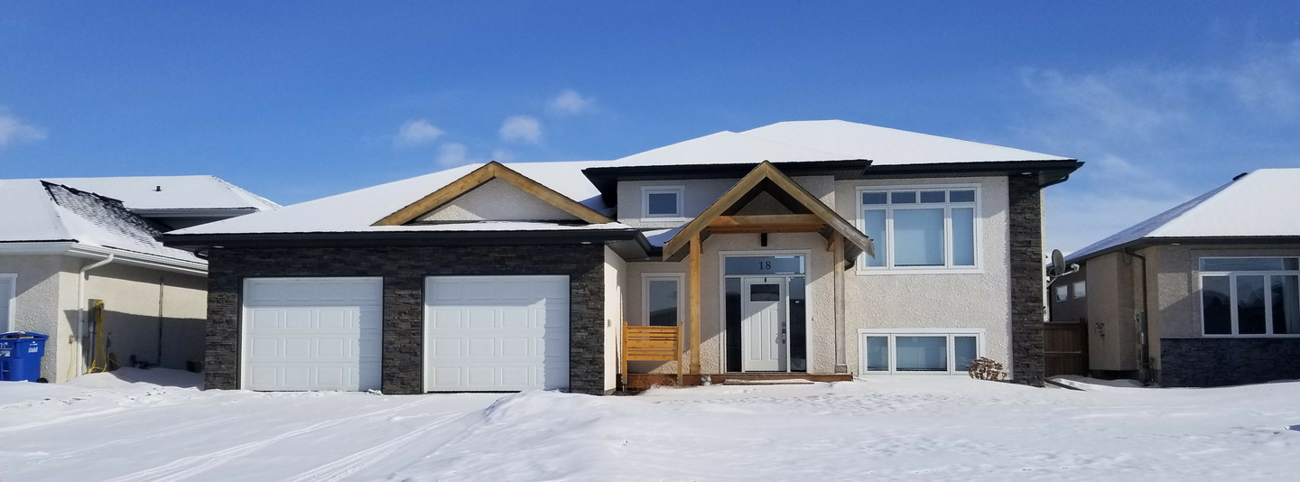 exterior winter view of completed custom home in Manitoba